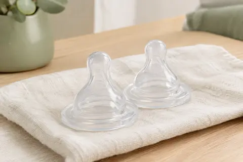 Deux tétines transparentes Avent Natural Response en silicone posées sur un linge ivoire