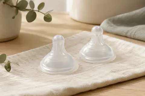 Deux tétines NaturalWave en silicone souple posées sur un linge clair dans un décor apaisant