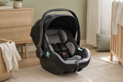 Siège-auto Lionelo Astrid i-Size noir et gris avec poignée rabattable et auvent pliable dans un intérieur clair