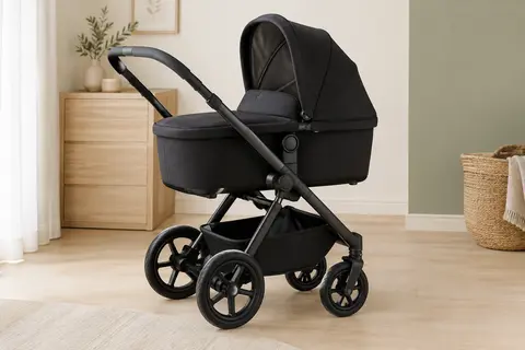 Poussette combinée noire avec nacelle, cadre en aluminium et quatre roues, dans un intérieur lumineux et sobre.